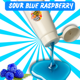 Candy top with blue liquid being poured, surrounded by blue raspberries on a blue and white background.